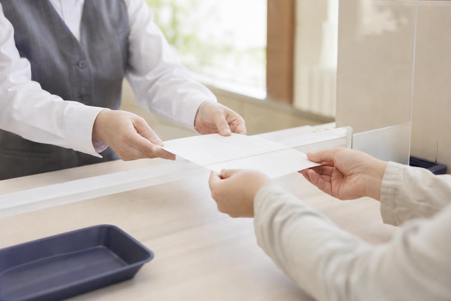 さいたま市の区役所窓口で葬祭費の申請書類を提出している様子